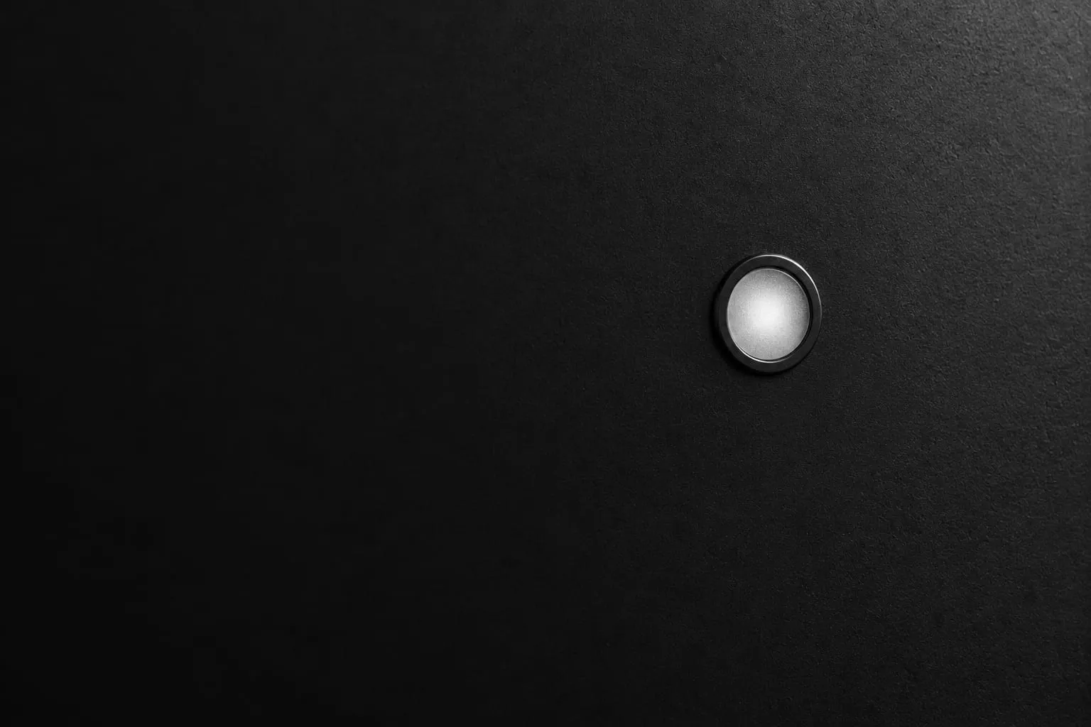 Uma única lâmpada indicadora acesa em um painel escuro